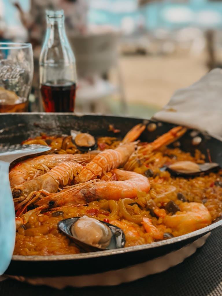 Draufsicht auf eine traditionelle spanische Meeresfrüchte-Paella mit Garnelen, Muscheln und Safranreis, serviert im Vivolo Olé in Berlin.